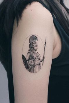 a woman with a tattoo on her arm holding a knife and wearing a headdress