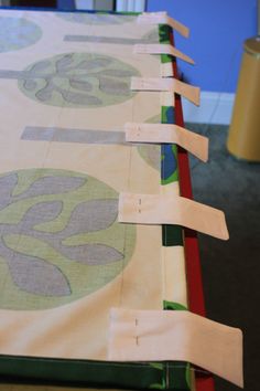 several pieces of fabric are laid out on a table to be made into wall hangings