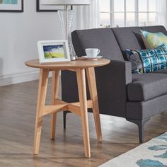 a living room with a couch, coffee table and pictures on the window sill