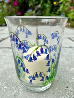 a glass with blue flowers painted on it