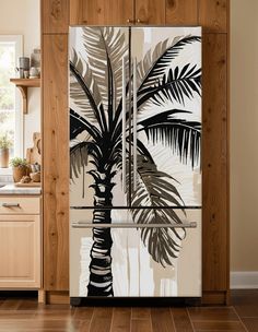 a palm tree painted on the side of a refrigerator in a kitchen with wooden cabinets