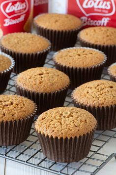 several muffins cooling on a wire rack next to cans of coca - cola