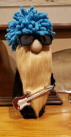 a close up of a stuffed animal with sunglasses on it's head and a guitar