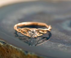 a gold ring with a diamond sitting on top of it