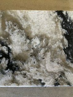 a black and white marble slab is shown in this close up view, with the top part of it partially covered by snow