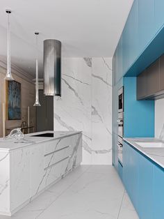 a kitchen with marble counter tops and blue cabinets in the center, along with an island