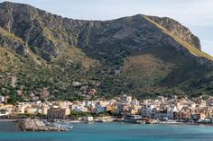 the city is surrounded by mountains and blue water