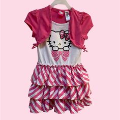 a pink and white dress with a hello kitty shirt on it's chest,