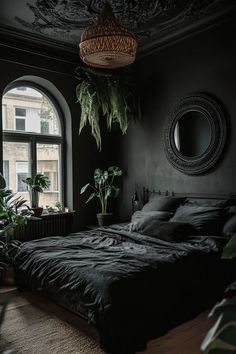 a bedroom with black walls and plants in the window sill, along with a large bed