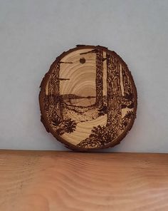 a piece of wood that has been carved to look like a tree stump with a landscape on it