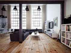 a living room filled with furniture and windows next to a wooden floor covered in books