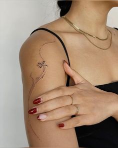 a woman's arm with a flower tattoo on the left side of her arm