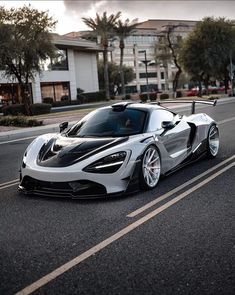 a white and black sports car driving down the street