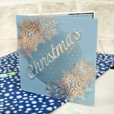 a blue christmas card with snowflakes on it