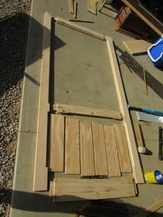 some tools are laying out on the ground next to wood planks and plywood