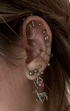 a woman's ear with several piercings attached to it