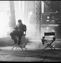 a man sitting in a chair next to a fire hydrant