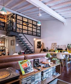 a living room filled with lots of furniture and books on top of a wooden table