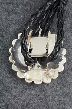 This mother of pearl, turquoise, onyx, coral and sterling silver inlay Zuni Sunface shaped bolo tie was made by Navajo silversmith Bryant Othole. The back is signed.Tie Length: 22 1/2"Length: 2"Width: 2"Tips:Length: 4 1/4"Width: 1 1/8"Free shipping on all orders! We ship with USPS and always include tracking. All orders ship within a day of payment.Returns are accepted up to 30 days after you receive your order. Just send us a message. Our shop offers cash back or store credit. The item must be Artisan Silver Lariat Bolo Tie, Artisan Bolo Ties With Sliding Knot As Gift, Artisan Bolo Tie With Sliding Knot As Gift, Artisan Bolo Ties With Sliding Knot For Gift, Adjustable Sterling Silver Bolo Tie For Gifts, Artisan Silver Bolo Tie With Concho, Adjustable Southwestern Jewelry With Polished Finish, Silver Lariat Bolo Tie For Gift, Artisan Adjustable Jewelry With Polished Finish