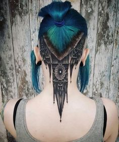 a woman with blue hair has a tattoo on her back neck and behind her ear