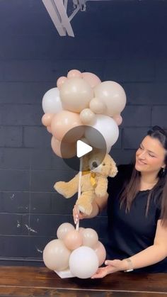 a woman is holding balloons and a teddy bear