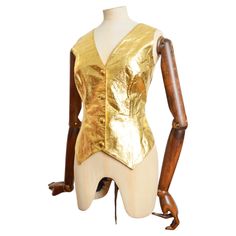 Vibrant 1990's Vintage Gold leather waistcoat by VALENTINO's 'Oliver' Label affectionally named after his favourite Pug. The Garment is crafted from a shiny Gold lamé leather with buttons down the front and a simple black reverse and interior lining. MADE IN ITALY. Measurements provided in Inches; Pit to Pit; 19’’ Waist; 32’’ Nape to Hem; 23’’ Recomended Size; UK 12 for a fitted silhouette / Or will fit smaller sizes if you desire a more oversized look. Condition; 7/10 - there are various minor Leather Waistcoat, Gold Lame, Moschino Cheap And Chic, Boucle Jacket, Evening Jackets, Black Crop, Gianni Versace, Jacket Buttons, Gold Leather