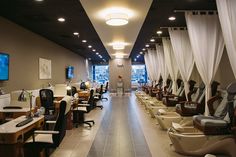 a room filled with lots of chairs covered in white drapes next to tall windows