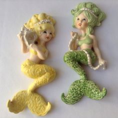 three little mermaid figurines sitting next to each other