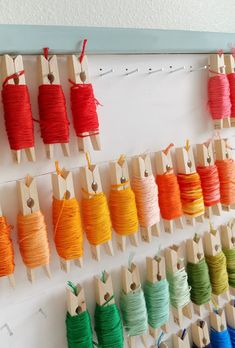 there are many spools of thread hanging on the wall