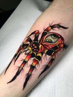 a spider tattoo on the arm with an eye