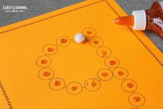 a close up of an orange sheet of paper with buttons on it next to a marker