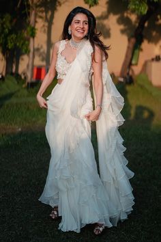 📌Hey! Please message us if you have any questions. We'll definitely assist you. This gorgeous white organza ruffle saree will elevate your sense of fashion and comes with a full-sequence blouse. The feminine touch that the tiny ruffles and translucent organza fabric bring to the entire design. The saree is skilfully made to drape nicely and provide a style that exudes easy charm. The full-sequence blouse gives this already gorgeous ensemble the perfect amount of glitz and shine. Onlookers will be amazed by the detailed sequence work, which is likely to catch the light. The blouse is made to fit precisely and improve the saree's overall appearance. This saree is a genuine showstopper and is ideal for weddings, parties, or any special occasion. With this classy and refined combination, you' Saree Modern Party Wear, Stitched Lehenga Ideas, Anjali Saree, Organza Ruffle Saree, Ruffle Saree Designs, Pelli Sarees, Trendy Lehenga Designs, Lehanga Saree, Farewell Saree