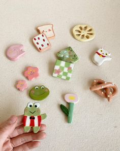 a hand holding a small assortment of toy items on top of a white carpeted floor