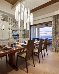 the dining room table is set with place settings for eight people, and has an ocean view