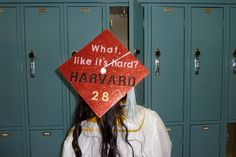 a woman wearing a red graduation cap with what like it? harvard written on it