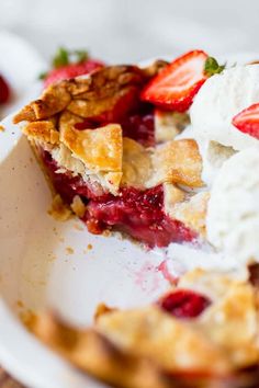 a piece of pie with whipped cream and strawberries in it on a white plate