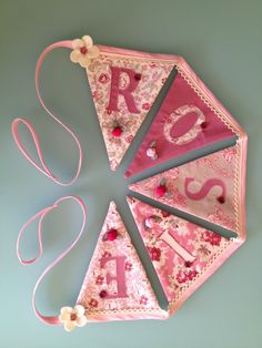 a pink kite with letters and flowers on it