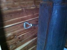 a wooden wall with a metal hook on it