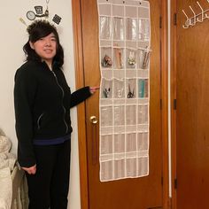 a woman standing in front of a door with a hanging organizer on it's side