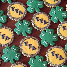 decorated cookies with letters and shamrocks are arranged on a brown tablecloth that says faith