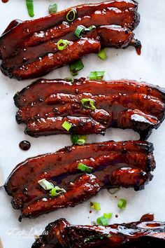 three cooked sausages with green onions and sauce