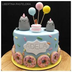 a birthday cake decorated with donuts and cats on wheels for the name adela