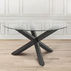 a glass table sitting on top of a hard wood floor next to a white wall