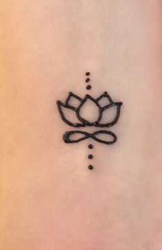 a lotus tattoo on the side of a woman's stomach, with dots in it