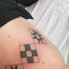 a woman with a tattoo on her thigh has a checkerboard design on it