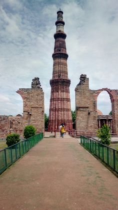 a tall tower sitting next to a lush green field