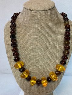 Stunning amber and glass bead necklace, 6 amber pieces surrounded by round, brown, glass beads.  26 inches long with brass lobster claw clasp. Adjustable Round Brown Beaded Necklace, Adjustable Brown Beaded Round Necklace, Adjustable Brown Round Beaded Necklace, Adjustable Brown Beaded Necklace, Brown Beaded Necklace With Oval Beads, Brown Beaded Necklaces With Oval Beads, Amber Necklace With Faceted Oval Beads, Handmade Brown Glass Jewelry, Adjustable Single Strand Brown Beads