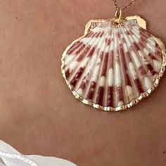 a close up of a person wearing a necklace with a shell on it's back