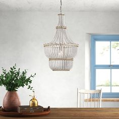 This 1-light tiered pendant light has a breezy and relaxed design that we love for your coastal living room or farmhouse dining room. It's made with a metal frame that supports four tiers of draped, white wooden beads with exposed rope accents that really make an antique statement in your space. Inside, this pendant takes a single standard bulb (sold separately) to brighten up all those family moments at home. Something to keep in mind: it comes with a fixed 38" hanging chain. Birch Lane™ Birch Coastal Living Room, Coastal Charm, Farmhouse Dining Room, Family Moments, Geometric Pendant, Farmhouse Dining, Birch Lane, Coastal Living, Wooden Beads