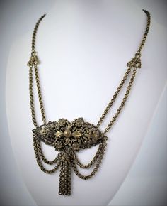 Reasonable offers are always considered  Gorgeous Victorian floral brass festoon tassel necklace. Beautiful draping. Chain measures 16 inches with center ornament measuring 3 inches wide and 2.75 inches long, including tassel.  Circa 1880-1900 Great vintage condition - some surface wear, as seen in photos. Will leave cleaning to buyer's discretion, as many collectors prefer the original patina. Please feel free to contact me with any questions. :) Bronze Necklace With Intricate Design For Formal Events, Victorian Necklace With Antique Finish, Elegant Decorative Brass Necklaces, Elegant Brass Necklaces With Decorative Details, Bohemian Necklace With Adjustable Chain For Formal Occasions, Bohemian Formal Necklace With Adjustable Chain, Victorian Brass Necklace For Vintage Events, Victorian Bronze Jewelry For Vintage Events, Elegant Brass Chain Necklace With Vintage Charm